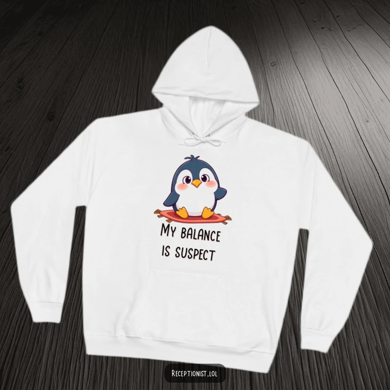 Funny penguin hoodie showing a surprised cartoon character hilariously tripping over a rug, offering comfort and humor.